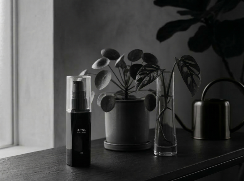 窓際の観葉植物と並べて飾られた、インテリアに馴染む美しいボトルの液体肥料EneBaute（エナボーテ）